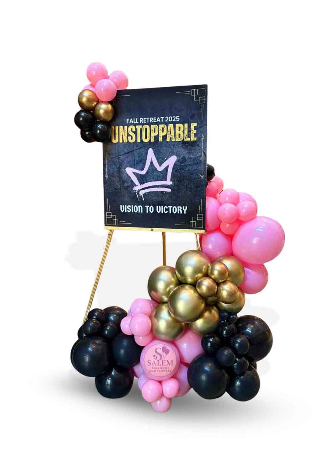 Organic balloon garland in black, pink and gold, decorating a welcome sign on an easel. Oregon